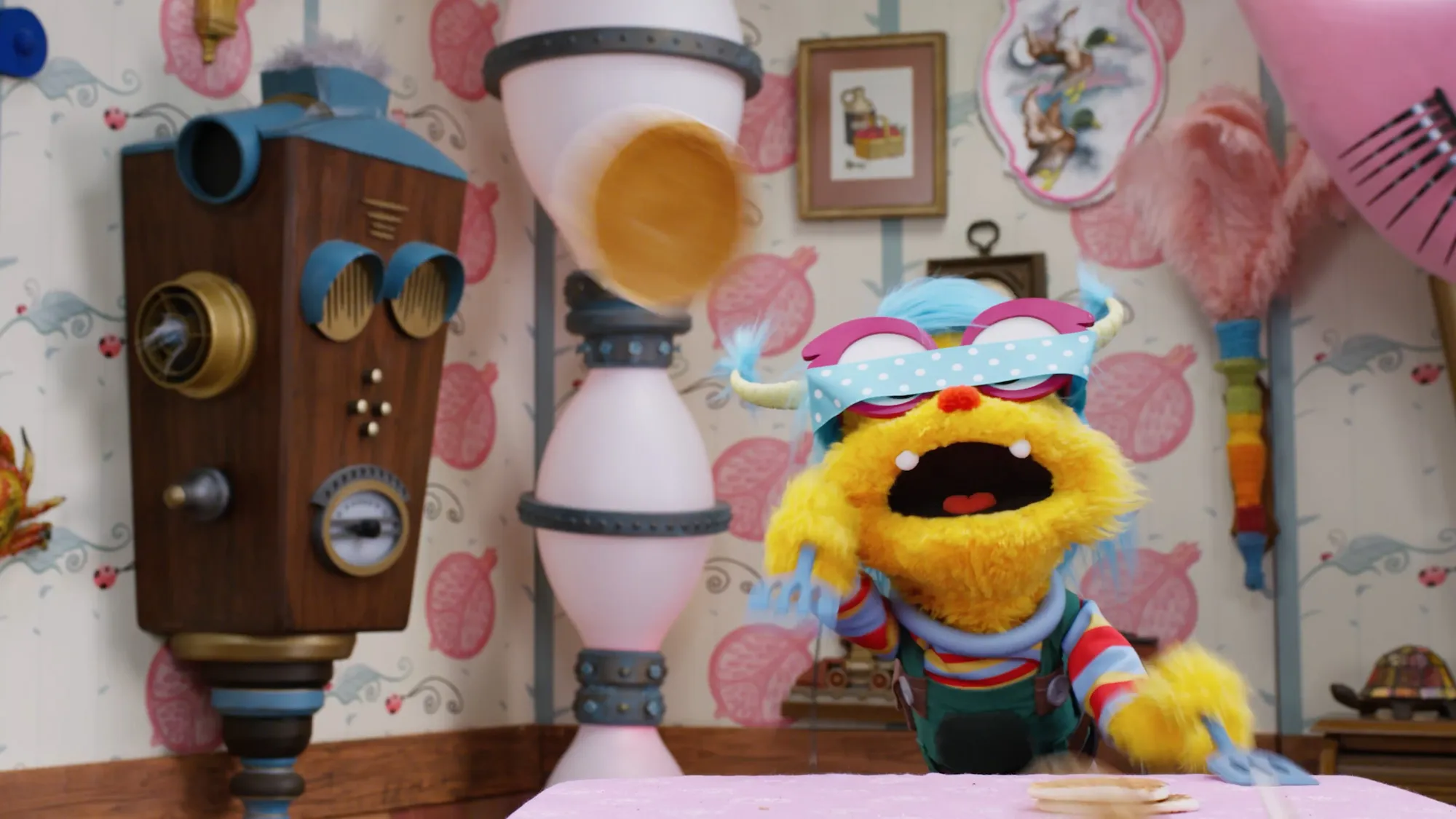 A yellow furry puppet character in the Albie's Elevator interior with the vintage radio-style elevator intercom panel beside it.