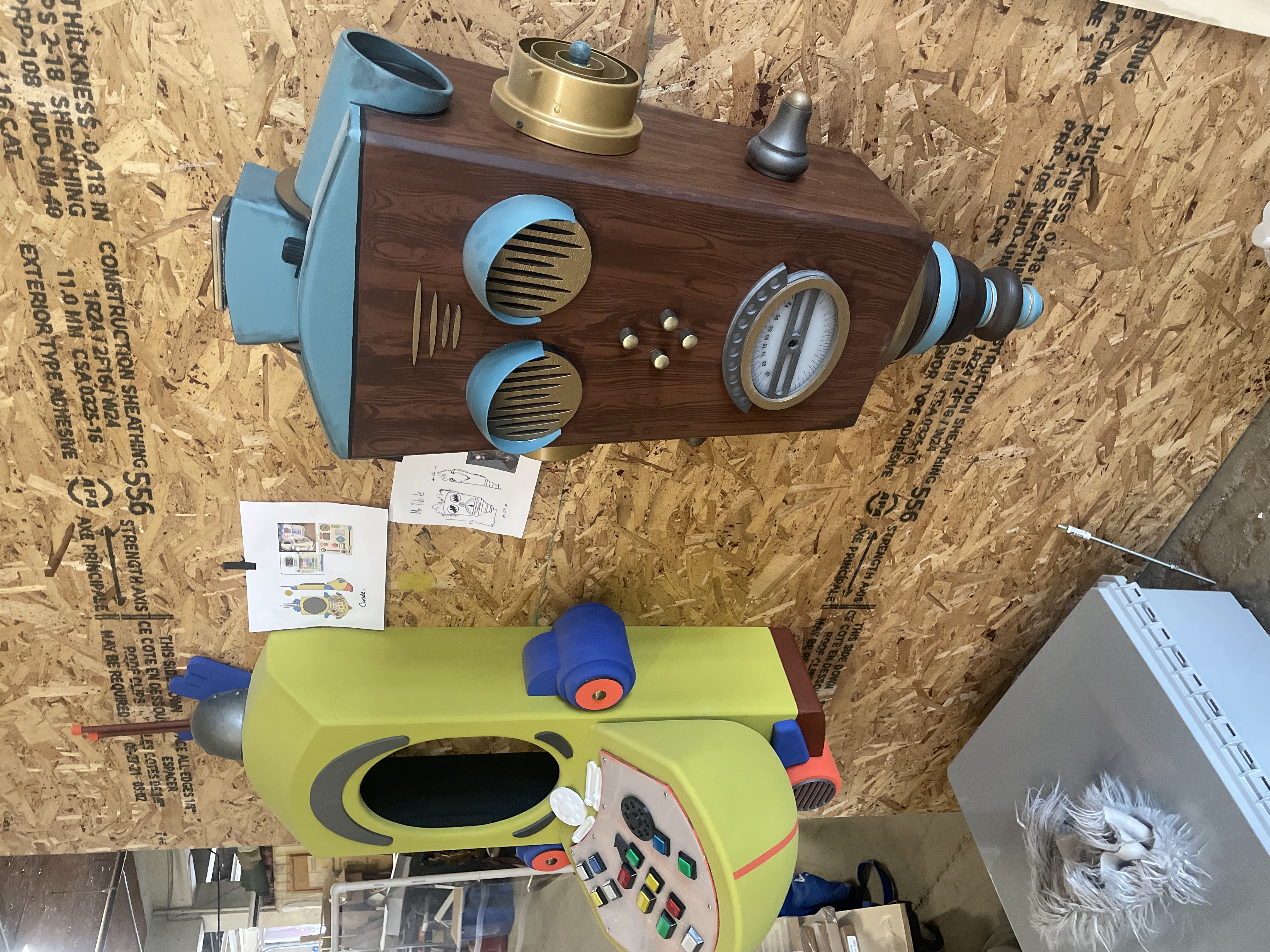 The elevator's wooden intercom panel and a partially-built puppet body on a workshop bench.