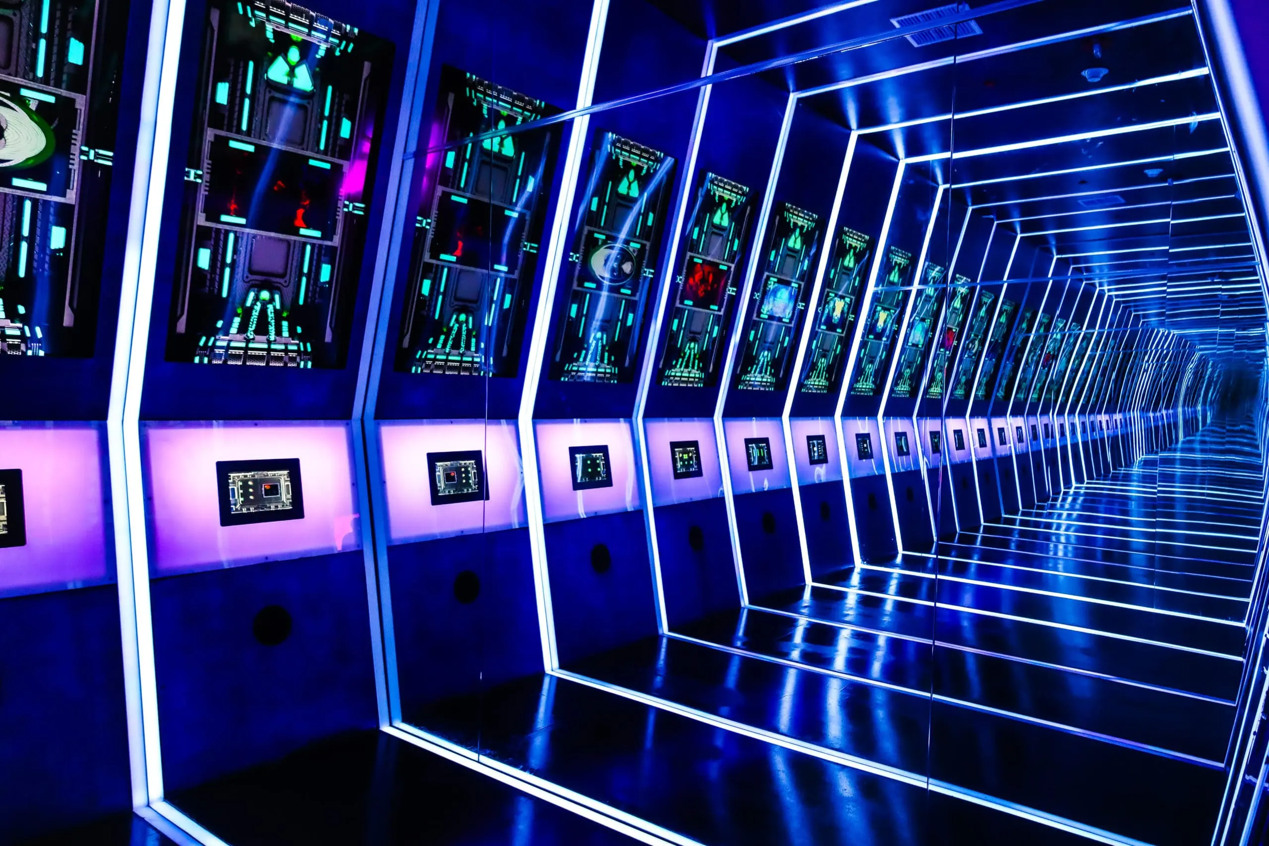 An immersive Otherworld exhibit lit with deep saturated color, blending sculptural form and architectural lighting.